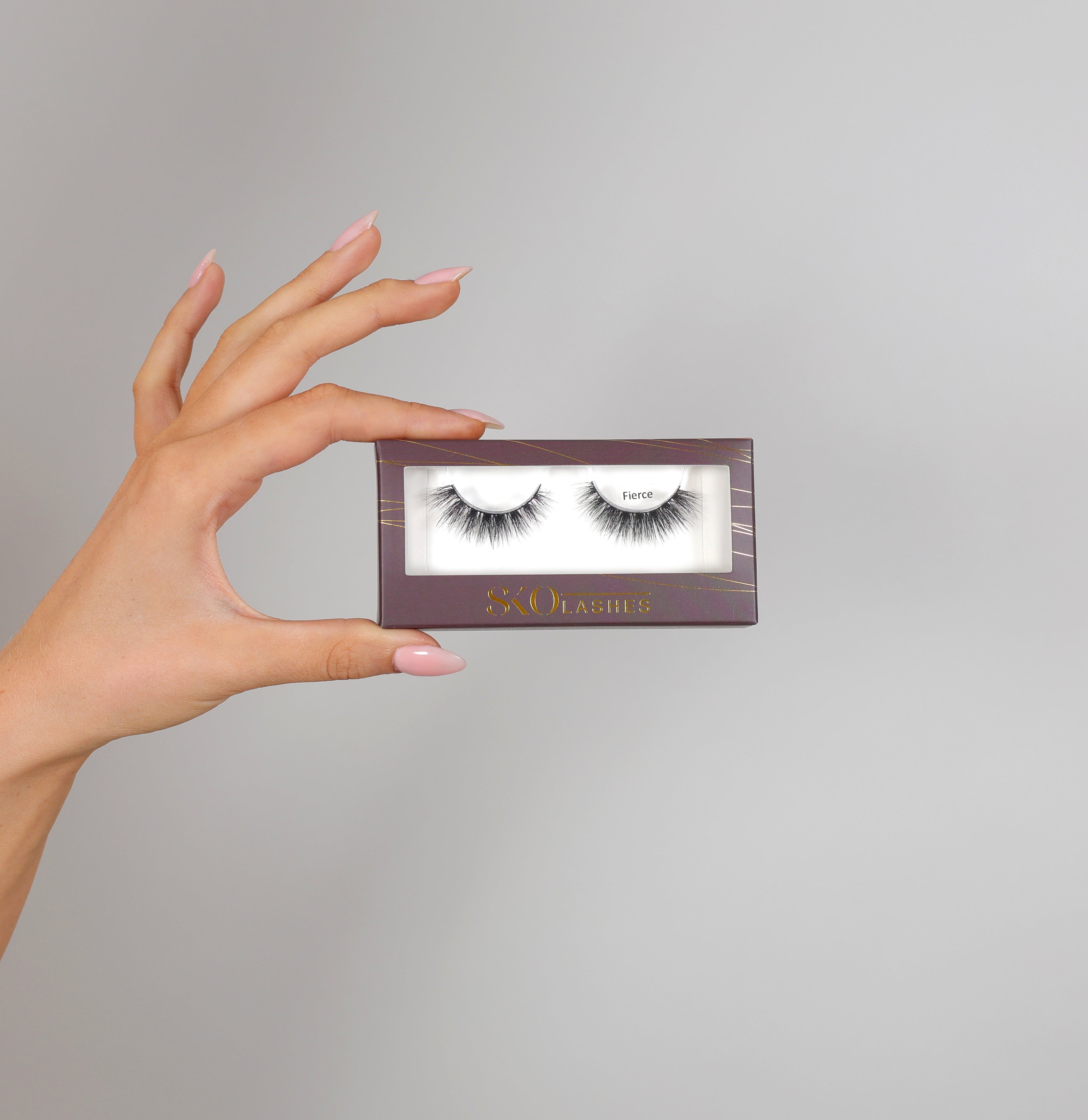 Client holding SKO FIERCE reusable false lashes box 